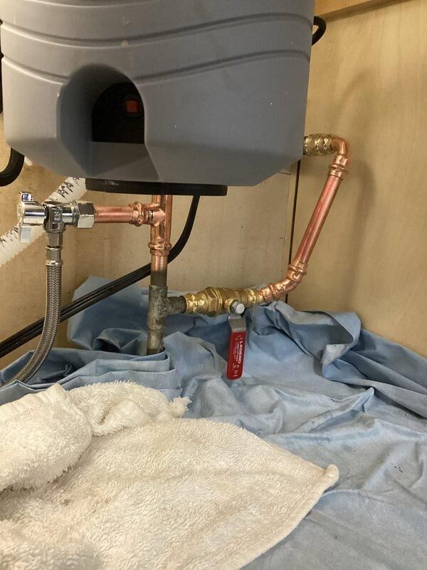 Responded to water leak under kitchen sink following recent remodel. Upon inspection, identified leaking connection at PVC drain elbow joint and loose fitting on chrome shut-off valve supplying flexible braided water line. Tightened all connections, replaced worn compression fittings, and secured drain assembly to eliminate leak points. Tested system under full water pressure to verify repair integrity and confirmed no active leaks present. All plumbing connections now functioning properly with no moisture detected.