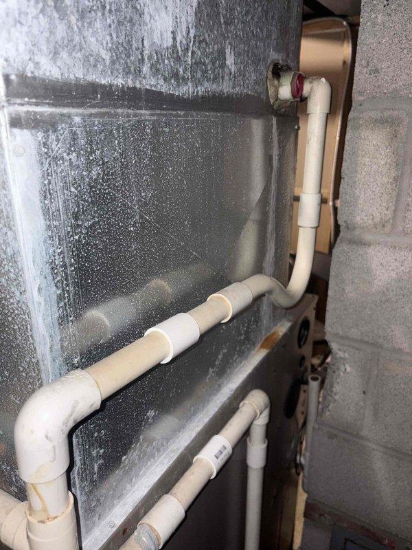 Inspected 35-year-old gas furnace with air conditioning system that customer reports is struggling to maintain temperature. Visual examination revealed multiple holes in the heat exchanger as previously identified by another technician. Documented extensive condensation on metal surfaces and photographed the current system configuration in preparation for full system replacement recommendation.