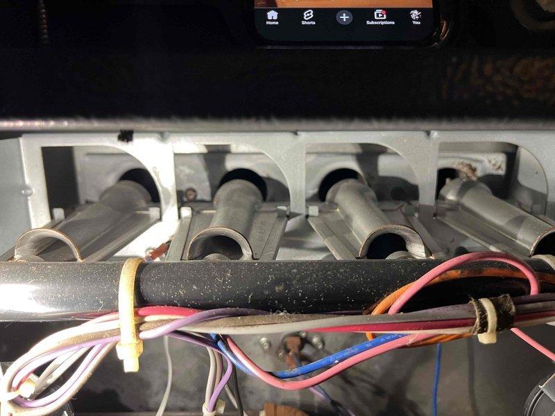 Conducted diagnostic inspection of HVAC system using borescope camera to examine interior condition of heat exchanger tubes. Visual inspection revealed signs of corrosion along edge of heat exchanger. Inspected electrical connections and wiring harness (red, blue, white, and yellow wires) to verify proper installation and identify potential issues contributing to furnace malfunction.