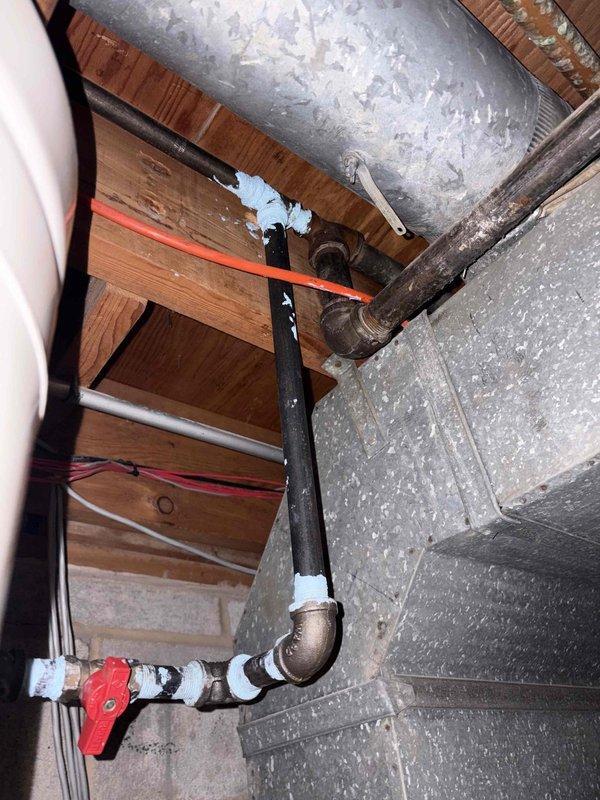 Completed comprehensive gas line inspection for new project with unknown system age. Inspected black iron gas piping in attic space with red-handled ball valve, verified connections and fittings, and examined dual Lochinvar water heater installation in basement with yellow flexible gas lines, multiple shut-off valves, and proper sediment traps. All gas line components, connections, and safety devices documented via photographs for project planning purposes.