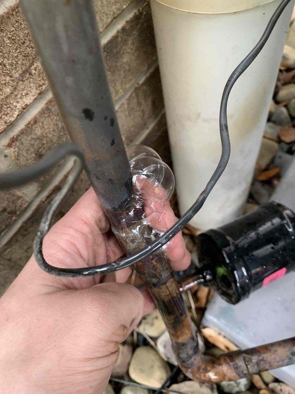 Performed nitrogen leak check on HVAC system after customer reported banging noise from AprilAir air handler. Inspected system components and documented conditions of water filtration system and associated plumbing showing significant sediment accumulation and copper pipe corrosion requiring attention.
