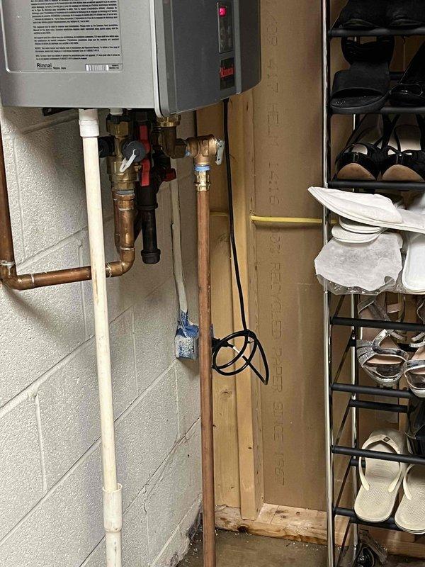 Mentor, OH - Responded to service call for leaking tankless water heater unit that was previously installed in 2021. Upon inspection, identified active leak originating from the dirt leg (sediment trap) assembly in the gas line piping below the unit. Assessed the copper piping connections, isolation valves, and pressure relief valve for related issues, documented the condition of the installation with photographs, and determined necessary repairs to address the leak at the dirt leg connection point.