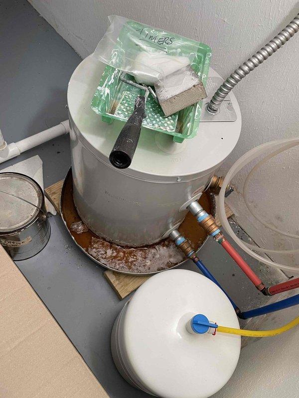 Responded to a no hot water and low water pressure complaint at a downstairs office location. Upon inspection, found a Bradford White Energy Saver tanked water heater with associated pressure components and plumbing connections. Evaluated the water heater system, pressure relief valve, expansion tank, and connected supply lines with brass fittings to diagnose the reported issues and restore proper hot water delivery and water pressure to the facility.